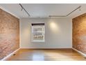 Spacious living room featuring hardwood floors and an exposed brick accent wall at 2306 Glenarm Pl # 206, Denver, CO 80205