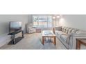Cozy living room featuring neutral-toned furniture, carpet flooring, and a large window for natural light at 3695 W Monmouth Ave, Littleton, CO 80123