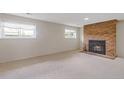 Finished basement with a cozy brick fireplace, carpet floors and bright windows at 2453 S Memphis Way, Aurora, CO 80013