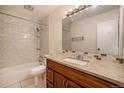 Bathroom featuring granite vanity, a shower-tub combo with tiled walls, and modern fixtures at 6800 E Tennessee Ave # 533, Denver, CO 80224