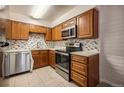 Modern kitchen features stainless steel appliances, sleek countertops, and wooden cabinets at 6800 E Tennessee Ave # 533, Denver, CO 80224