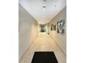 Long hallway with neutral walls, tiled floor, and artwork at 1144 Rockhurst Dr # 105, Highlands Ranch, CO 80129