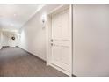 Hallway with carpet and a white entry door to a condo unit at 1144 Rockhurst Dr # 105, Highlands Ranch, CO 80129