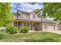 Spacious two-story home with a covered front porch, beautiful landscaping, brick accents, and an attached two-car garage at 5483 Gunnison Dr, Frederick, CO 80504