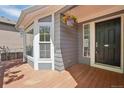 Cozy front porch featuring wood flooring, white trim, and a hanging flower basket, enhancing curb appeal at 19157 E Progress Ave, Centennial, CO 80015