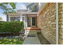 Inviting front porch with stone accents and a well-manicured lawn, providing a welcoming entrance at 19157 E Progress Ave, Centennial, CO 80015