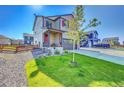 Two-story house with red accents and a landscaped yard at 128 Monarch St, Bennett, CO 80102