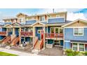 Beautiful multi-level townhome featuring blue siding, a stone base, and a red door at 619 Brennan Cir, Erie, CO 80516