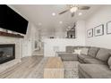 Open-concept living room featuring a gray sofa, fireplace, and wood-style flooring at 619 Brennan Cir, Erie, CO 80516