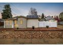 Charming single-story home with solar panels and a decorative rock garden, enhancing curb appeal at 3001 Benton St, Wheat Ridge, CO 80214