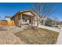 Side view of the home with a covered porch and well-manicured lawn at 1820 Taos St, Brighton, CO 80603