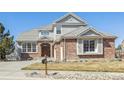 Stunning two-story home with a brick facade, well-manicured lawn, and charming curb appeal at 6503 S Quemoy Way, Aurora, CO 80016