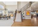 Grand foyer with soaring ceilings, hardwood floors, and a striking staircase with wrought iron railings at 6503 S Quemoy Way, Aurora, CO 80016