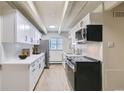 Clean kitchen with white cabinets, modern appliances, and herringbone tile backsplash at 1180 Yosemite St # 110, Denver, CO 80220
