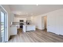 Open-concept kitchen with stainless steel appliances, white cabinets, island, and access to the outside from large sliding glass doors at 15285 Milwaukee St, Thornton, CO 80602