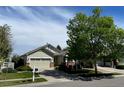 Inviting single-story home with a lush front yard and a two-car garage at 1128 S Duquesne Cir, Aurora, CO 80018