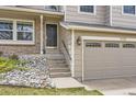 A front exterior shot of a tan home with brick accents and an attached two-car garage at 6382 Freeport Dr, Highlands Ranch, CO 80130
