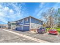Two-story townhome featuring a private balcony, multiple garages, and ample parking, highlighted by blue siding and classic design at 1287 S Wheeling Way, Aurora, CO 80012