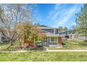 Inviting townhome with a brick facade, a well-manicured lawn, and mature trees enhancing the curb appeal and charm at 1287 S Wheeling Way, Aurora, CO 80012