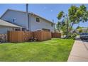 Exterior view of a well-maintained home with a lush lawn, complemented by a privacy fence at 1211 W 112Th Ave # B, Denver, CO 80234