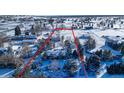 Snow-covered property, outlined in red, with a house surrounded by snow covered mature trees at 8530 W Jefferson Ave, Denver, CO 80235