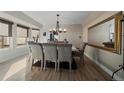 Bright dining room featuring hardwood floors, a modern chandelier, and a large mirror reflecting natural light at 6251 S Iola Ct, Englewood, CO 80111