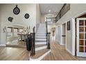 Open foyer with hardwood floors, staircase with decorative wrought iron, and views of the dining room and upper level at 6251 S Iola Ct, Englewood, CO 80111