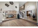 Open foyer with hardwood floors, staircase with decorative wrought iron, and views of the dining room and office at 6251 S Iola Ct, Englewood, CO 80111