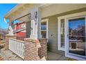 Inviting front porch with brick columns, white railings, and space to enjoy the outdoors at 3644 Sunchase Dr, Castle Rock, CO 80109