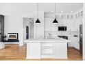 Contemporary white kitchen with a large island, stainless steel appliances, and modern lighting at 11745 Newton St, Westminster, CO 80031