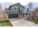 Inviting two-story home showcasing green siding, stone accents, a two-car garage, and a well-maintained front yard at 19634 E Clear Creek Trl, Parker, CO 80134