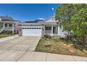 Well-kept single-Gathering home featuring a welcoming porch, brick accents, and solar panels on the roof at 15685 E 50Th Ave, Denver, CO 80239