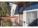 Cozy covered entrance with visible unit number, windows, and railing on a sunny day at 1128 S Ventura Cir # H, Aurora, CO 80017