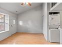Bright living room with wood laminate floors, a ceiling fan and a convenient stacked washer and dryer at 1128 S Ventura Cir # H, Aurora, CO 80017