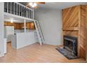 Open-concept living space with fireplace, kitchen, and a ladder leading to the loft area at 1128 S Ventura Cir # H, Aurora, CO 80017