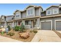Charming townhome featuring a gray exterior, landscaped front yard, and attached one-car garage at 226 Ash St, Bennett, CO 80102