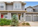 Gray townhome with a charming front porch, well-maintained landscaping, and an attached one-car garage at 226 Ash St, Bennett, CO 80102
