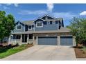 Beautiful two-story home with blue siding, brick accents, and a spacious three-car garage at 879 Quintana Ln, Erie, CO 80516