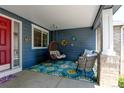 Cozy front porch features hanging chair, seating and colorful decor at 879 Quintana Ln, Erie, CO 80516