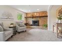 Cozy living room with a brick fireplace, plush carpet, and comfortable seating at 2173 S Ouray St, Aurora, CO 80013