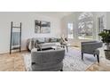Bright living room with large windows, modern decor, and stylish furniture at 1737 Jules Ct, Highlands Ranch, CO 80126