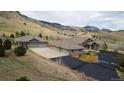 Stunning aerial view of estate property with a sprawling home, large garage, and beautiful mountain backdrop at 5881 Deer Meadow Trl, Golden, CO 80403