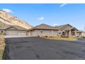 Sprawling ranch-style home with a brick facade, multiple garages, and a scenic mountain backdrop at 5881 Deer Meadow Trl, Golden, CO 80403