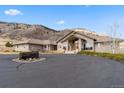 Inviting brick home featuring a circular driveway with unique vintage wagon wheel accent and mountain views at 5881 Deer Meadow Trl, Golden, CO 80403