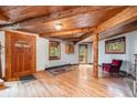 Cozy living room with beautiful wood floors, exposed beams, and natural light creating a warm and inviting atmosphere at 10419 Christopher Dr, Conifer, CO 80433