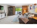 Inviting living room with comfortable gray sectional, wood accents, and sliding glass doors to the balcony at 2880 S Locust St # 305N, Denver, CO 80222