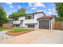 Two-story home featuring an attached garage and a neatly landscaped front yard at 2843 S Otis St, Denver, CO 80227