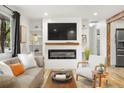 Bright living room featuring a modern fireplace, a large television, and comfortable seating arrangements at 6742 Marshall St, Arvada, CO 80003