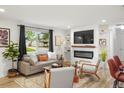 Cozy living room with a modern fireplace, a large window, comfortable seating, and stylish décor at 6742 Marshall St, Arvada, CO 80003