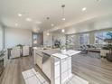 Spacious kitchen island flows to an open floor plan with light wood flooring and ample natural light at 22083 E 38Th Pl, Aurora, CO 80019